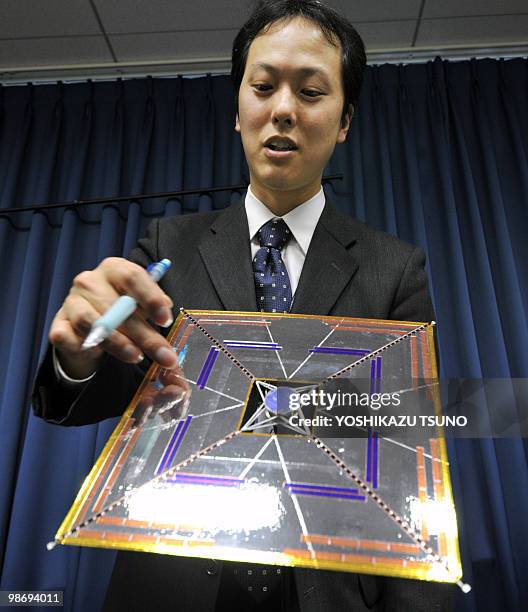 Yuichi Tsuda, a researcher from Japan's Aerospace Exploration Agency displays a model of a new Japanese satellite Ikaros , during a press conference...