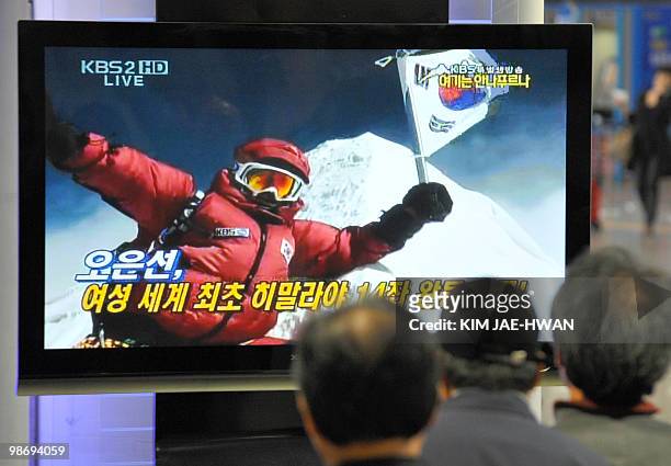 South Koreans watch live television as Oh Eun-Sun plants her national flag on the summit of Annapurna, an 8,091-metre mountain, in Seoul on April 27,...