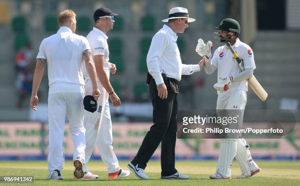 Umpire Paul Reiffel intervenes as Mohammad Hafeez of Pakistan and Ben Stokes of England exchange words during the 1st Test match between Pakistan and...