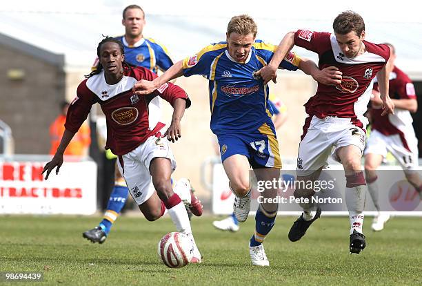 Benjamin Van Der Broek of Shrewsbury Town moves between Paul Rodgers and Peter Gilbert of Northampton Town during the Coca Cola League Two Match...