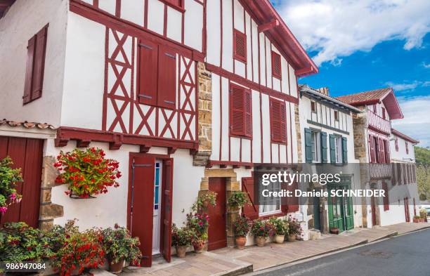 france, basque country, bastide-clairence (labelled "most beautiful village in france"), alignment of houses in regional style - baskenland stockfoto's en -beelden