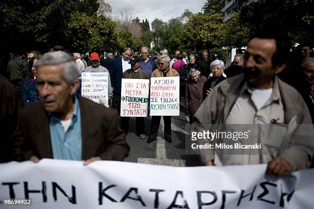 Pensioners hold banners condemning the rise in the cost of medicines during a demonstration in front of the Prime Ministers office on March 3, 2010...