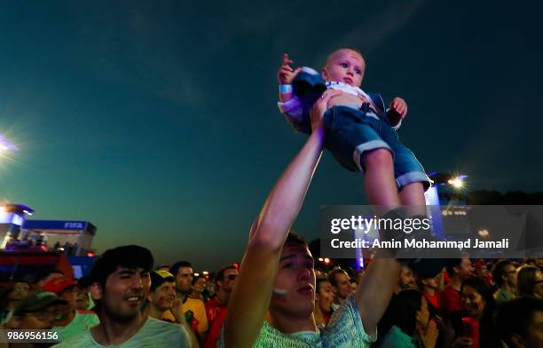 Fan holds up a baby in fan fest of Moscow on June 28, 2018 in Moscow, Russia.