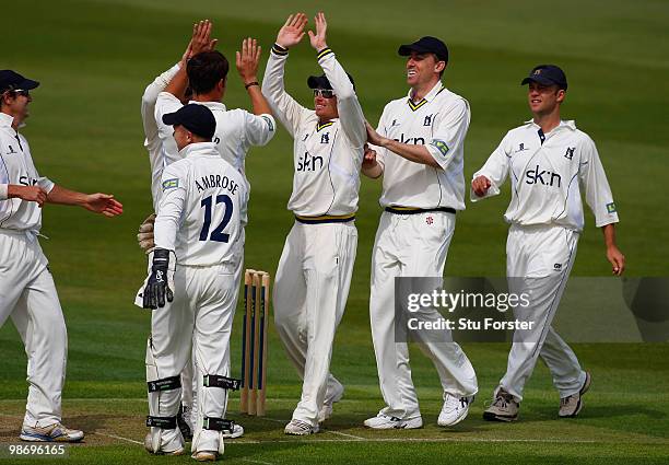 Warwickshire bowler Neil Carter is congratulated by team mates after taking a wicket during day one of the LV County Championship division one match...