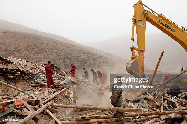 Soldier monitors a excvavtor searching on the debris of houses destroyed in the Yushu earthquake at the Changu Temple of Jiegu Township on April 25,...