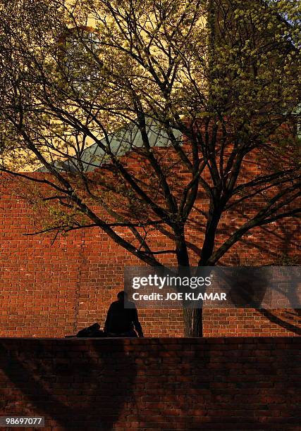 Man sits on a wall in Old town in Warsaw on April 15, 2010. Poland mourns for 96 people who died in an aircrash on April 10. Late Polish President...