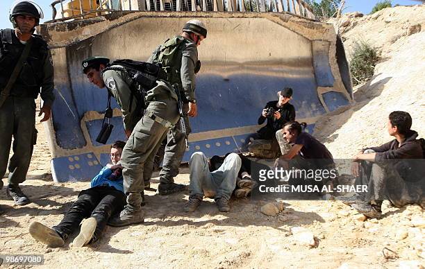 Israeli soldiers restrain protesters during a demonstration by Palestinian and foreign peace activists against the construction of a section of...