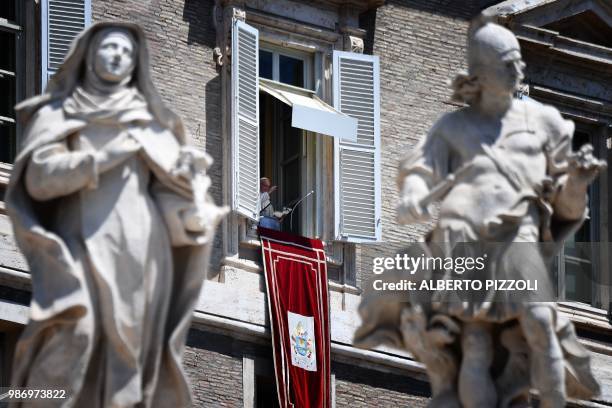 Pope Francis addresses the crowd from the window of the apostolic palace overlooking St.Peter's square during his Angelus prayer on June 29, 2018 at...