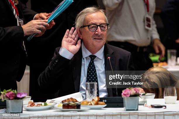 President of the European Commission Jean-Claude Juncker gestures as he sits down ahead of roundtable discussions on the final day of the European...