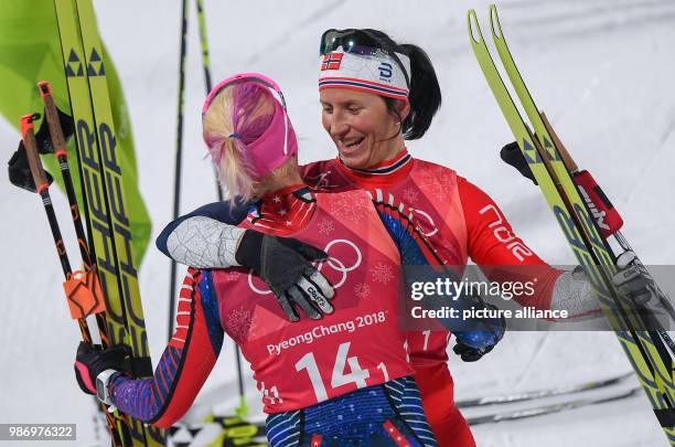 Marit Bjoergen from Norway congratulating at the finish line Kikkan Randall from the US for her gold medal during the women's free team sprint nordic...