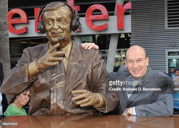 Los Angeles Kings television play-by-play Announcer, Bob Miller, poses for a photo with the bronze statue of late Los Angeles Lakers play-by-play...