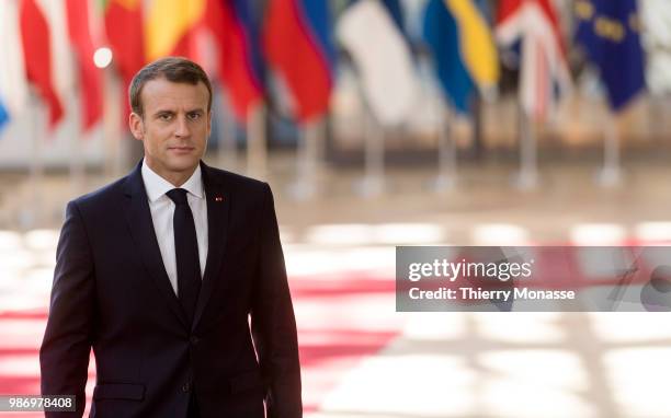 France's President Emmanuel Macron speaks to journalists as he arrives to take part in the second day of the European Union leaders' summit, without...