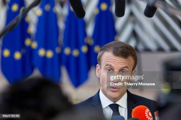 France's President Emmanuel Macron speaks to journalists as he arrives to take part in the second day of the European Union leaders' summit, without...