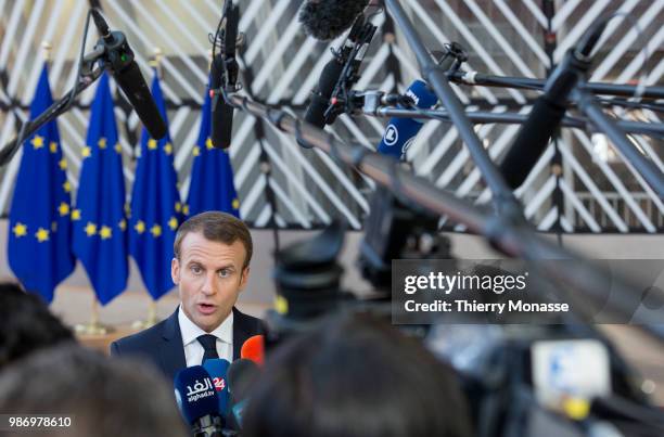 France's President Emmanuel Macron speaks to journalists as he arrives to take part in the second day of the European Union leaders' summit, without...