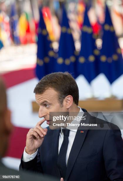 France's President Emmanuel Macron speaks to journalists as he arrives to take part in the second day of the European Union leaders' summit, without...