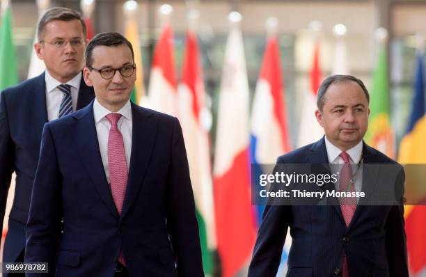 Polish Prime Minister Mateusz Morawiecki arrives for an EU Summit at European Council on June 29, 2018 in Brussels, Belgium. He is flanked by the...