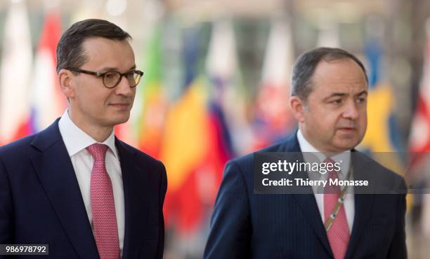 Polish Prime Minister Mateusz Morawiecki arrives for an EU Summit at European Council on June 29, 2018 in Brussels, Belgium. He is flanked by the...