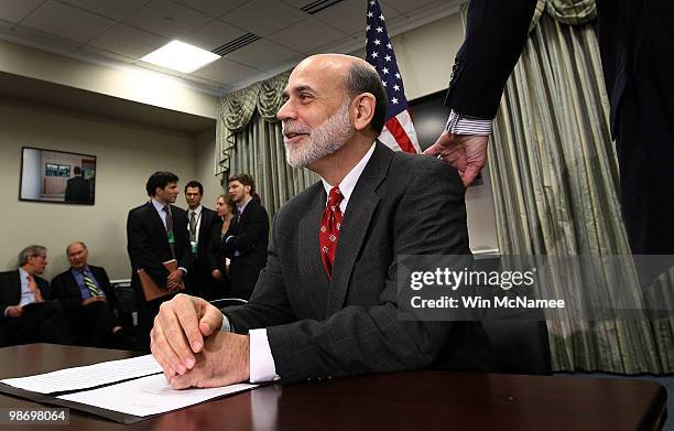 Federal Reserve Chairman Ben Bernanke gets a pat on the back from an attendee of the National Commission on Fiscal Responsibility and Reform before...