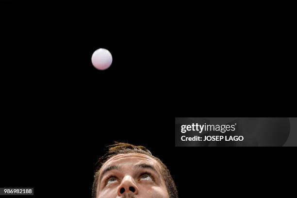 Tunisian Adam Hman eyes the ball during his men's table tennis group A team match 2 at the XVIII Mediterranean Games in Valls, near Tarragona on June...