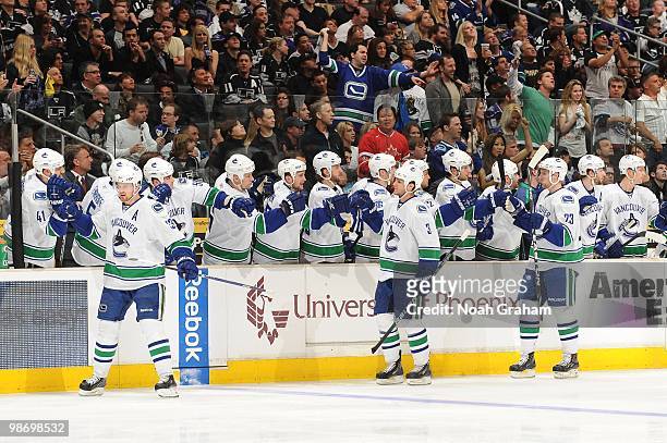 Henrik Sedin, Kevin Bieksa and Alexander Edler of the Vancouver Canucks celebrate with the bench after a goal against the Los Angeles Kings in Game...