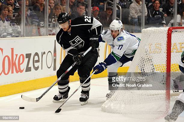 Jeff Halpern of the Los Angeles Kings skates with the puck against Ryan Kesler of the Vancouver Canucks in Game Six of the Western Conference...