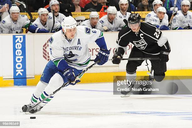 Sami Salo of the Vancouver Canucks skates with the puck against Dustin Brown of the Los Angeles Kings in Game Six of the Western Conference...