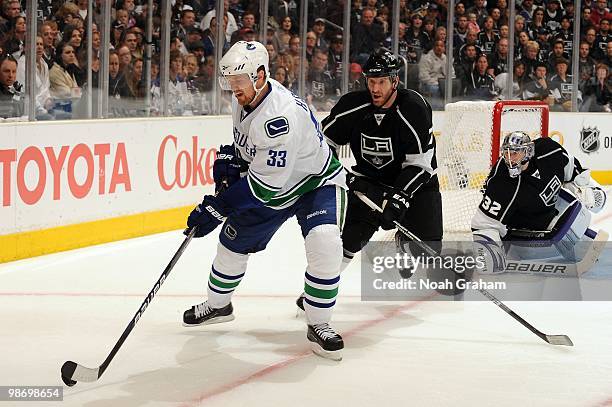 Henrik Sedin of the Vancouver Canucks skates with the puck against Rob Scuderi of the Los Angeles Kings in Game Six of the Western Conference...