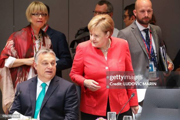 Hungary's Prime Minister Viktor Orban speaks with Germany's Chancellor Angela Merkel during the last day of the European Union leaders' summit,...