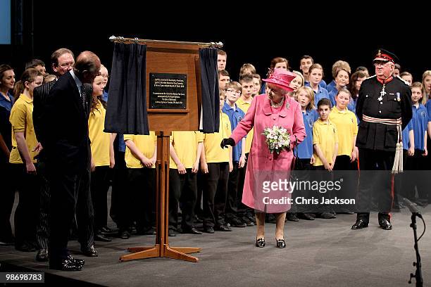 Queen Elizabeth II unveils a plaque as Prince Philip, Duke of Edinburgh looks on during a visit to the Venue Cymru Arena on April 27, 2010 in...