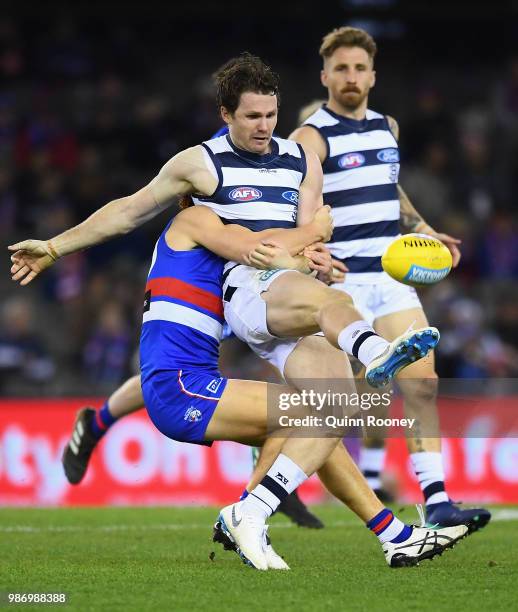 Patrick Dangerfield of the Cats kicks whilst being tackled by Ed Richards of the Bulldogs during the round 15 AFL match between the Western Bulldogs...