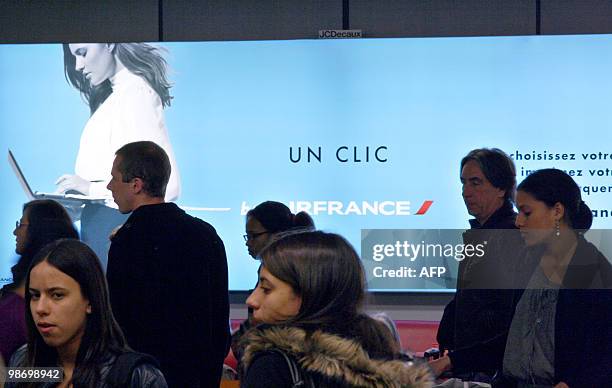 Passengers pass by an advertising board about the French airline company Air France on April 20, 2010 at Orly airport, south of Paris. The two main...