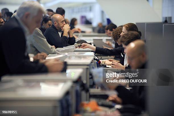 Passengers complete check-in formalities before boarding Air France flights on April 20, 2010 at the Roissy-Charles-de-Gaulle airport, north of...