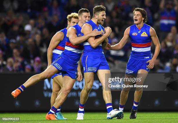 Marcus Bontempelli of the Bulldogs is congratulated by team mates after kicking a goal during the round 15 AFL match between the Western Bulldogs and...