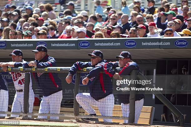 Scott Ullger, Steve Liddle, Rick Anderson and Ron Gardenhire of the Minnesota Twins watch the game from the dugout against the Cleveland Indians at...