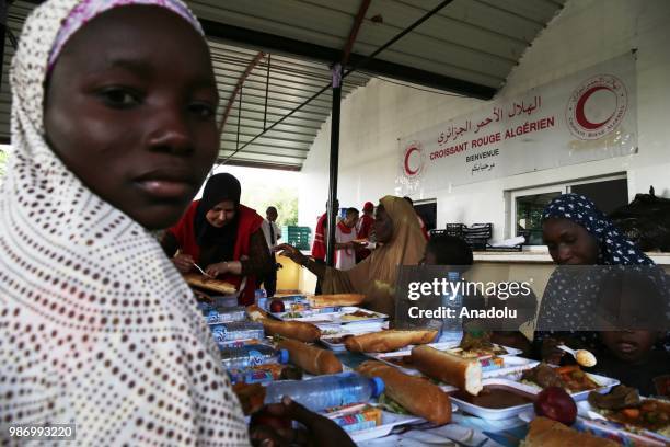 African migrants who were arrested in Algeria while illegally attempting to get to Europe, have meal before leaving the refugee camp located in the...