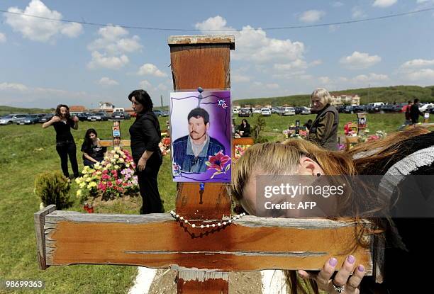 Kosovo Albanian woman cries in front of a grave as she pays tribute during a ceremony to mark the Day of Missing Persons at the cemetery in the...