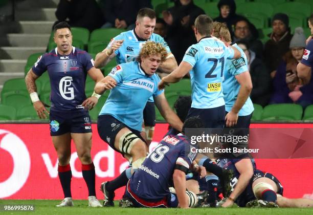 Ned Hanigan of the Waratahs is congratulated by his teammates after scoring a try during the round 17 Super Rugby match between the Rebels and the...