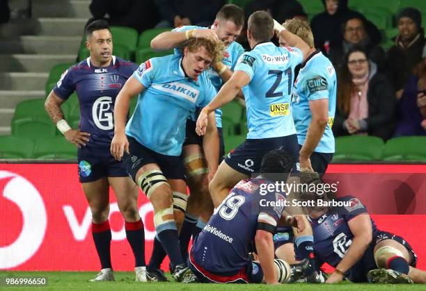 Ned Hanigan of the Waratahs is congratulated by his teammates after scoring a try during the round 17 Super Rugby match between the Rebels and the...