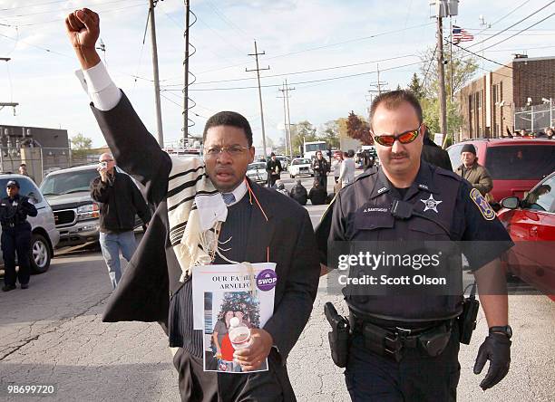 Rabbi Joshua Salter is lead away after being arrested for blocking a street to prevent vehicles from the Immigration and Customs Enforcement...