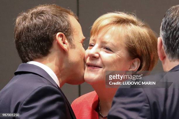 France's President Emmanuel Macron kisses Germany's Chancellor Angela Merkel during the last day of the European Union leaders' summit, without...