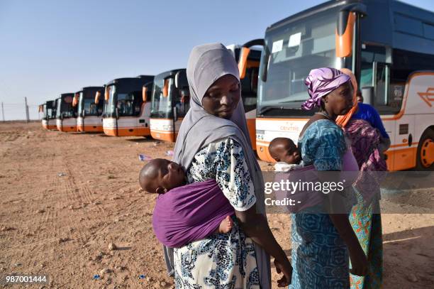 Nigerien migrants in Algeria wait next to buses as they are repatriated by Algerian authorities back to Niger on June 29 in Laghouat, northern...