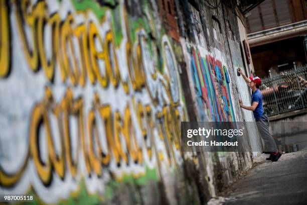 In this handout image provided by Red Bull, Kris Kolanus of Poland paints graffiti art prior to second stop at the Red Bull Cliff Diving World Series...