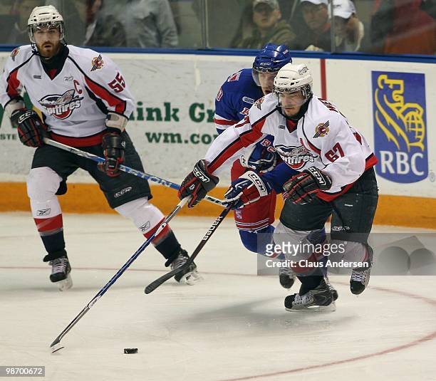 Eric Wellwood of the Windsor Spitfires tries to skate away with the puck in Game 6 of the Western Conference Final against the Kitchener Rangers on...