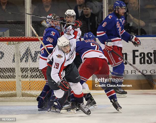 Zack Kassian of the Windsor Spitfires is knocked off stride by John Moore of the Kitchener Rangers in Game 6 of the Western Conference Final on April...