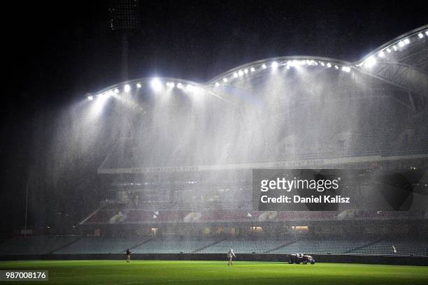 Adelaide Oval ground staff help prepare the ground for tomorrow's AFL game after the round 16 NRL match between the Sydney Roosters and the Melbourne...