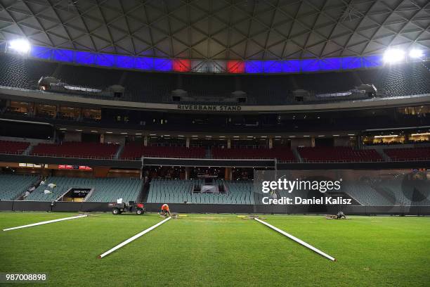 Adelaide Oval ground staff help prepare the ground for tomorrow's AFL game after the round 16 NRL match between the Sydney Roosters and the Melbourne...