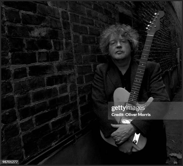 Portrait of Pulitzer Prize-winning Irish poet and educator Paul Muldoon, as he poses with his guitar, with which he performs in the rock band...