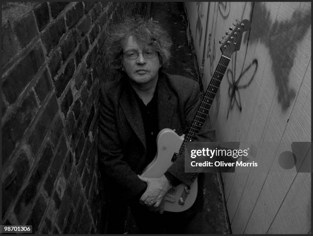 Portrait of Pulitzer Prize-winning Irish poet and educator Paul Muldoon, as he poses with his guitar, with which he performs in the rock band...