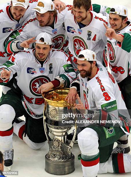 Ak Bars Kazan's ice hockey players pose wit hthe trophy as they celebrate their victory 2-0 over HC MVD Balashikha in the seventh play-off game...