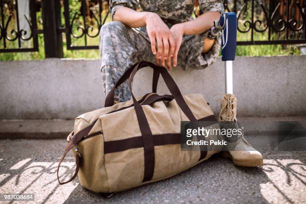 depressed soldier with amputee leg waiting for someone to pick him up - us army urban warfare stock pictures, royalty-free photos & images
